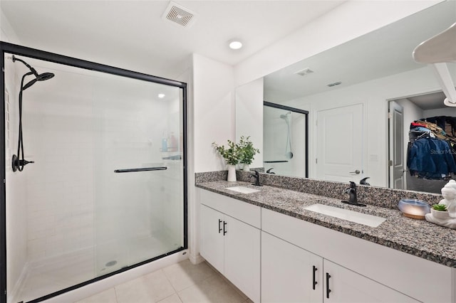 bathroom with tile patterned floors, vanity, and a shower with shower door