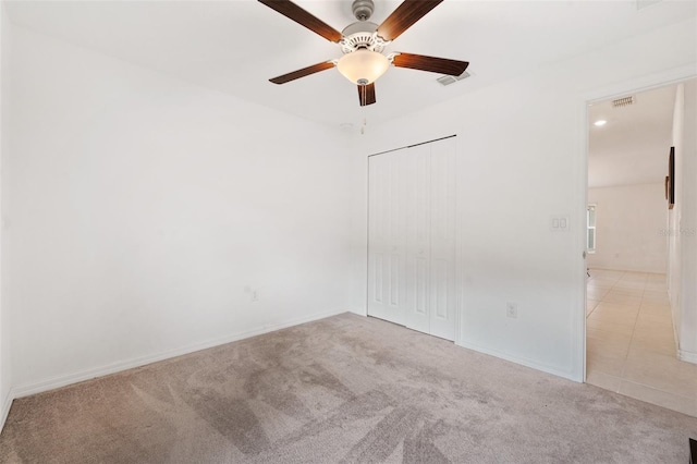 spare room featuring ceiling fan and light colored carpet