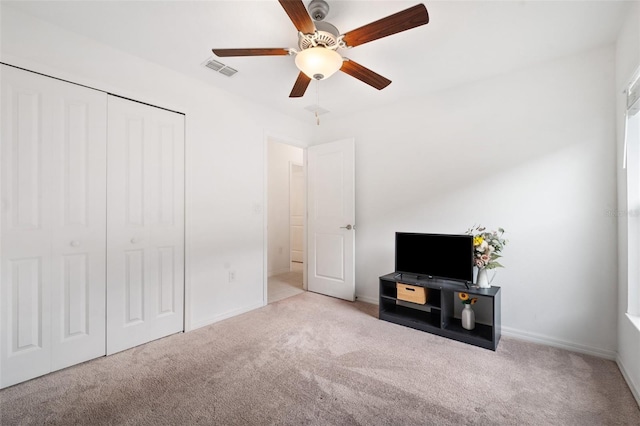 interior space featuring ceiling fan and light colored carpet