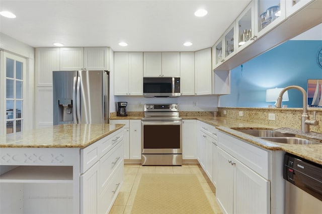 kitchen featuring light stone counters, stainless steel appliances, sink, white cabinets, and light tile patterned flooring