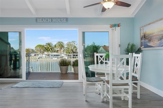 interior space with beam ceiling, ceiling fan, and a water view