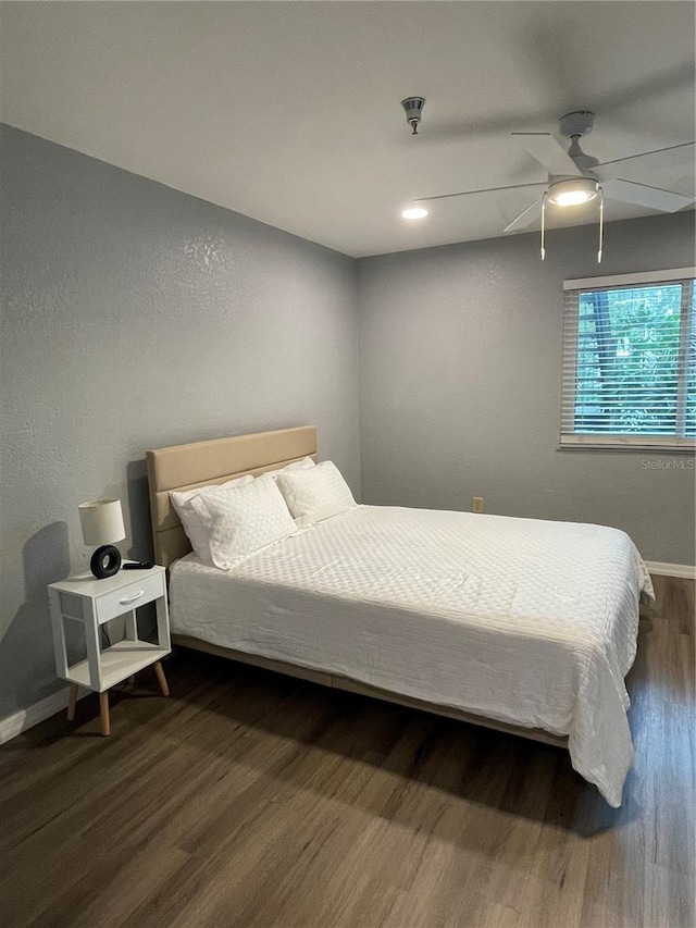 bedroom with ceiling fan and dark wood-type flooring