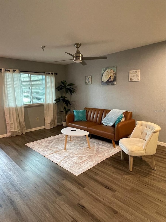 living room featuring ceiling fan and dark hardwood / wood-style floors