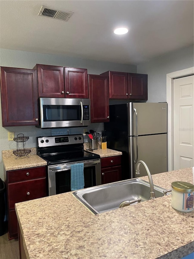 kitchen featuring hardwood / wood-style floors, appliances with stainless steel finishes, and sink