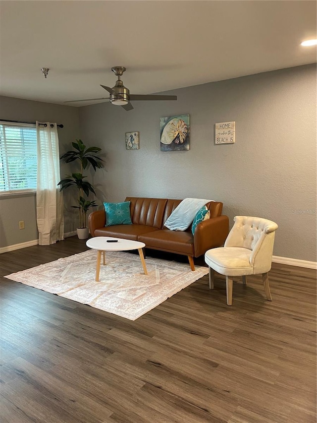 living room featuring ceiling fan and dark wood-type flooring