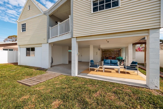 back of house featuring outdoor lounge area, a yard, a balcony, and a patio area