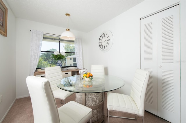 dining area with carpet floors and a textured ceiling