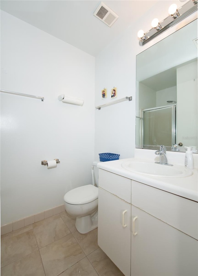 bathroom featuring tile patterned flooring, vanity, toilet, and an enclosed shower