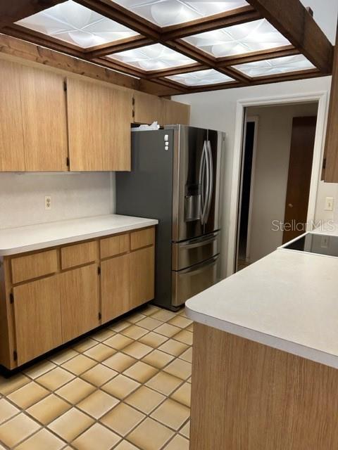 kitchen featuring light tile patterned flooring and stainless steel fridge with ice dispenser