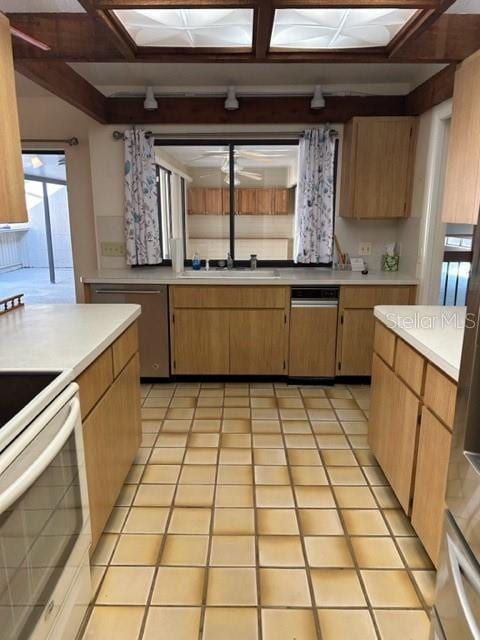 kitchen with electric range, dishwasher, light tile patterned flooring, and sink