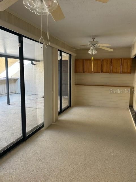 carpeted spare room with ceiling fan