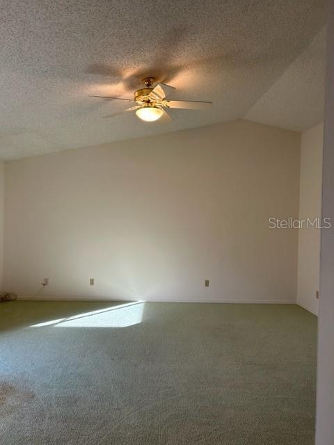 empty room featuring ceiling fan and lofted ceiling