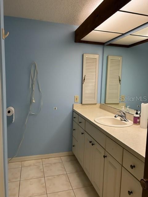 bathroom featuring tile patterned flooring, vanity, and a textured ceiling