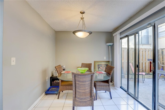 tiled dining area featuring a textured ceiling