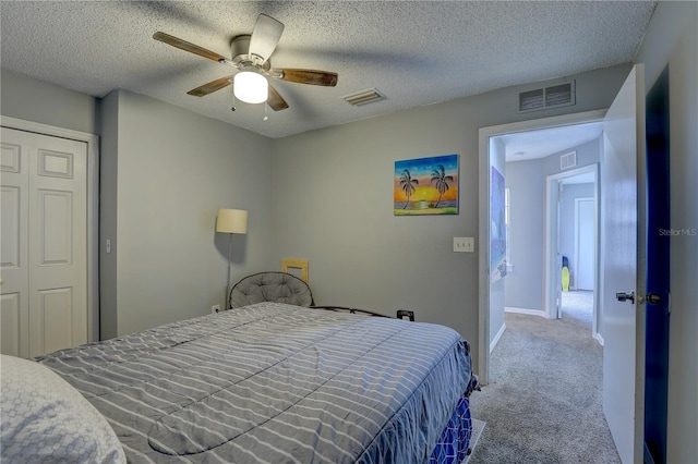 carpeted bedroom featuring a textured ceiling, a closet, and ceiling fan