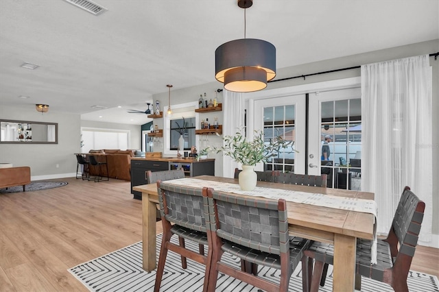 dining room featuring ceiling fan, french doors, and light hardwood / wood-style flooring