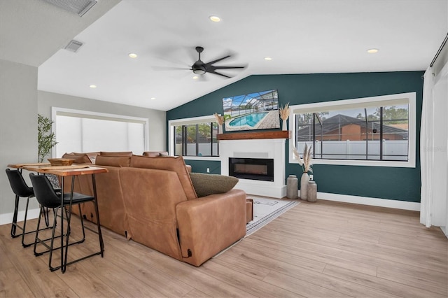 living room featuring light wood-type flooring, vaulted ceiling, and ceiling fan