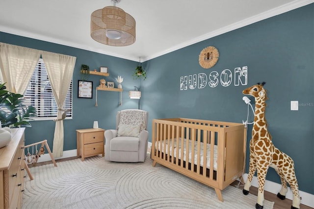 bedroom with a crib and crown molding