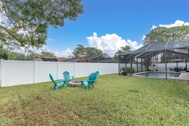 view of yard with a fenced in pool, glass enclosure, and an outdoor fire pit