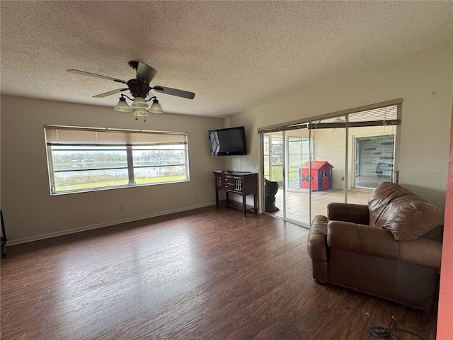 living room featuring ceiling fan, a textured ceiling, and dark hardwood / wood-style floors