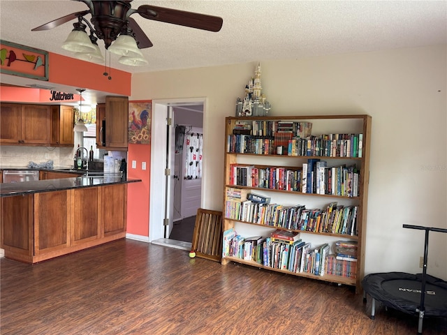 kitchen featuring ceiling fan, backsplash, dark hardwood / wood-style floors, a textured ceiling, and sink