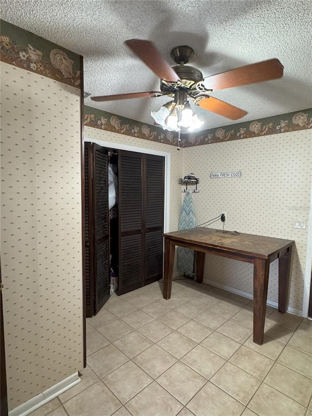 unfurnished office featuring a textured ceiling, ceiling fan, and light tile patterned floors