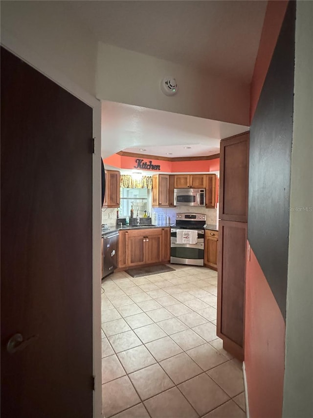 kitchen featuring light tile patterned floors, backsplash, and stainless steel appliances