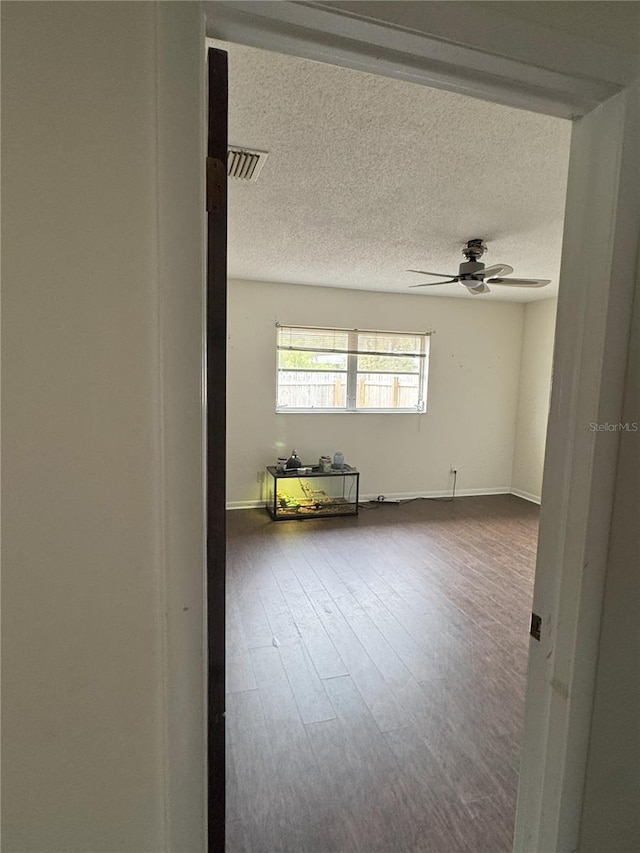 spare room with ceiling fan, a textured ceiling, and hardwood / wood-style floors