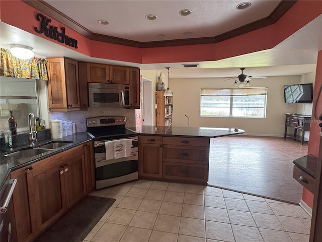 kitchen featuring pendant lighting, sink, appliances with stainless steel finishes, ornamental molding, and light tile patterned floors