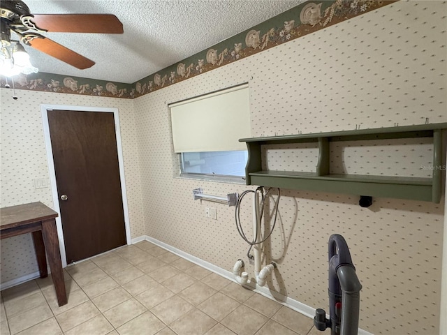 laundry area featuring ceiling fan, light tile patterned floors, gas dryer hookup, and a textured ceiling