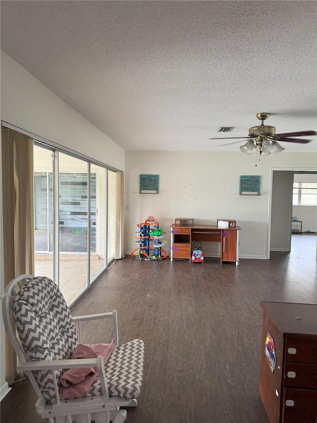 interior space featuring ceiling fan, dark hardwood / wood-style flooring, and a textured ceiling