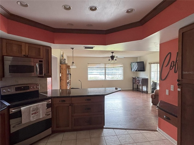 kitchen featuring light tile patterned floors, ceiling fan, stainless steel appliances, ornamental molding, and pendant lighting