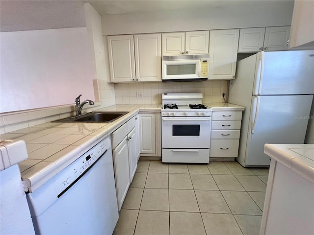 kitchen featuring tile counters, white cabinetry, sink, and white appliances