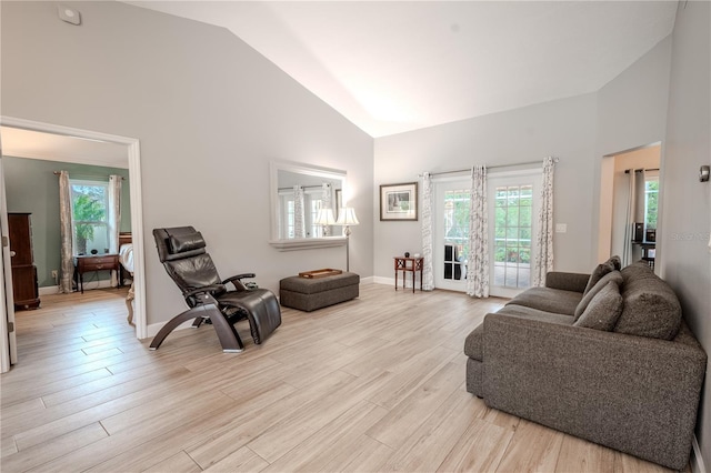 living room featuring high vaulted ceiling and light wood-type flooring