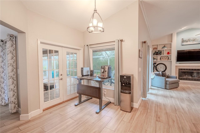 home office with french doors, lofted ceiling, built in features, a tile fireplace, and light hardwood / wood-style floors