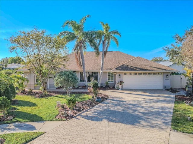 ranch-style home featuring a garage and a front yard