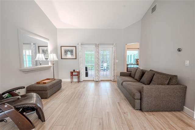 living room featuring lofted ceiling and light hardwood / wood-style floors