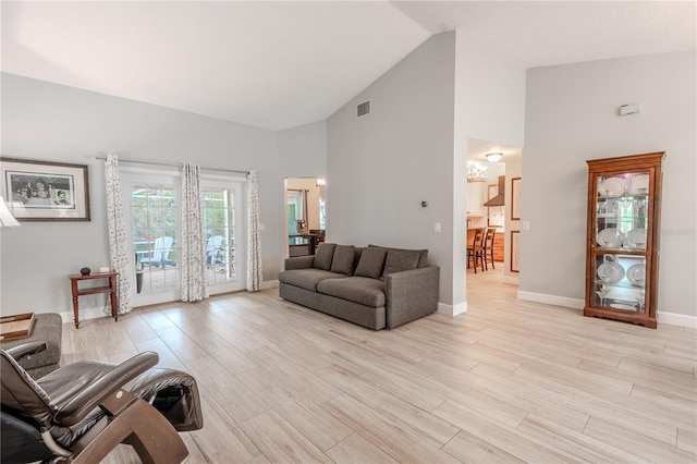 living room with high vaulted ceiling and light wood-type flooring