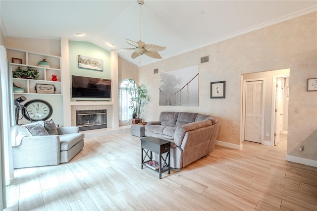 living room with a fireplace, lofted ceiling, ceiling fan, light hardwood / wood-style floors, and built in shelves