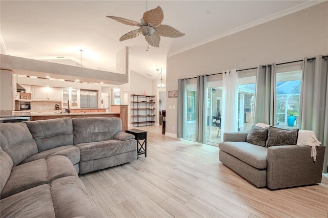 living room featuring lofted ceiling, ceiling fan with notable chandelier, light hardwood / wood-style flooring, and ornamental molding