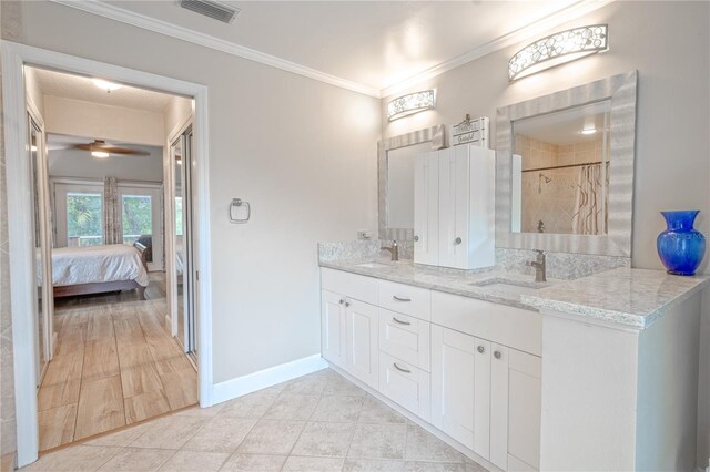 bathroom with vanity, crown molding, tile patterned floors, and a tile shower