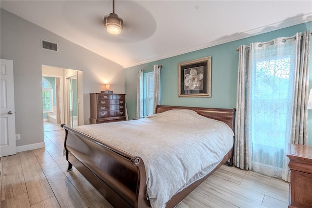 bedroom with ceiling fan, lofted ceiling, light hardwood / wood-style floors, and ensuite bath