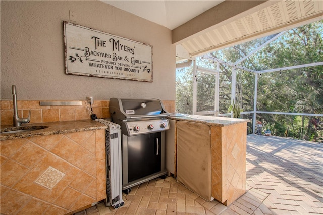 view of patio with a grill, a lanai, and sink