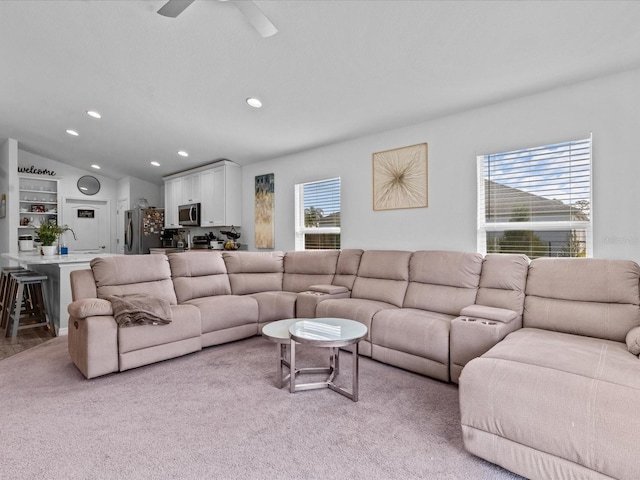 living room featuring ceiling fan, light colored carpet, and vaulted ceiling