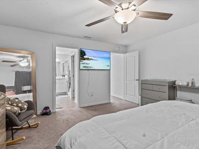 bedroom with light colored carpet, ensuite bath, and ceiling fan