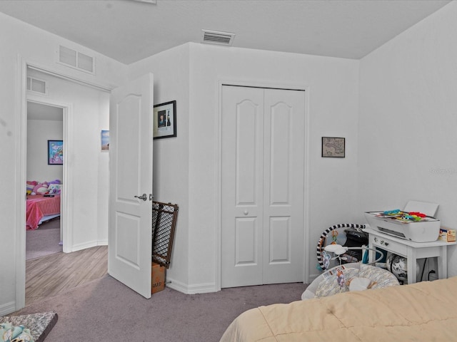 bedroom with light colored carpet and a closet