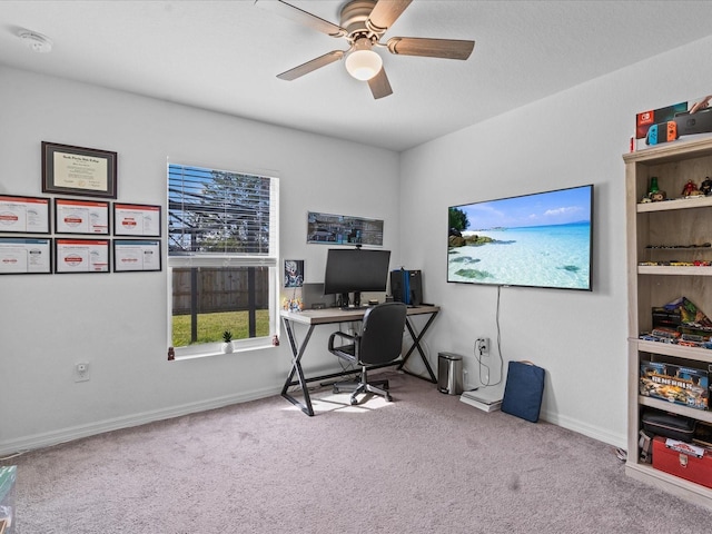 carpeted home office featuring ceiling fan