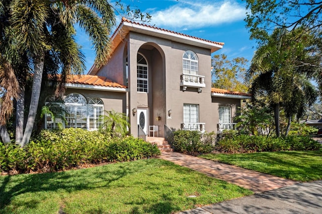 mediterranean / spanish-style house featuring a front yard