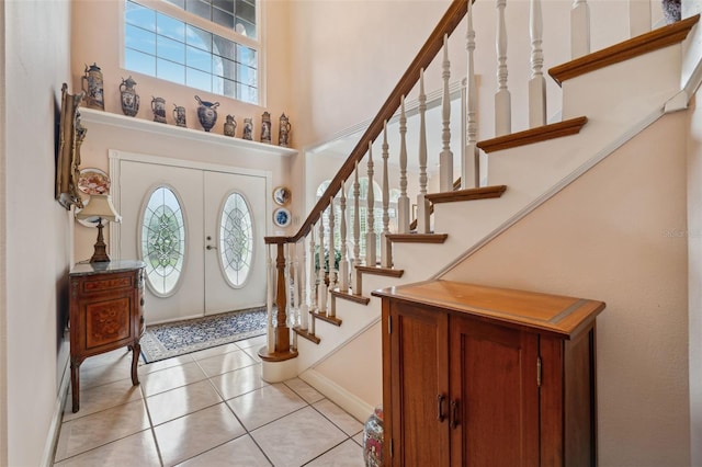 tiled entryway featuring a towering ceiling and french doors