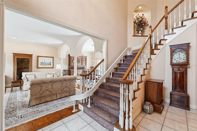 stairs featuring tile patterned floors and a chandelier